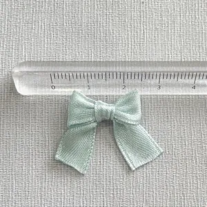 Macro detail of a 3.5cm handmade satin ribbon bow used for DIY crafts and hair accessories