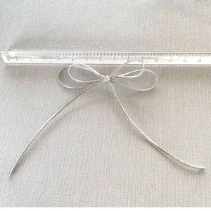 Silberne PU-Schleife mit 9,5 cm Breite, dargestellt mit Lineal zur Größenskala