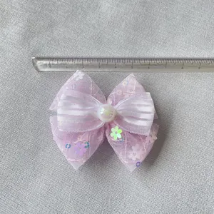 Dettaglio di fiocco rosa con rete glitter, paillettes e perla bianca per accessori fai-da-te