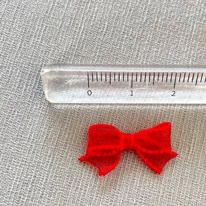 Detailed view of a 2.2cm small red mesh bow accessory with measuring ruler display