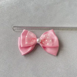 Vista dettagliata di un fiocco rosa a due strati con pois bianchi e perla ornamentale