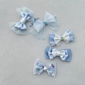 Detail van handgemaakte blauwe haarstrikken met parels, pailletten en satijnen linten