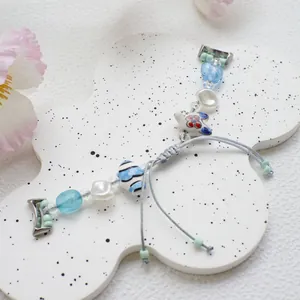 Detail of handmade beaded watch strap featuring ceramic beads and pearls in soft blue tones