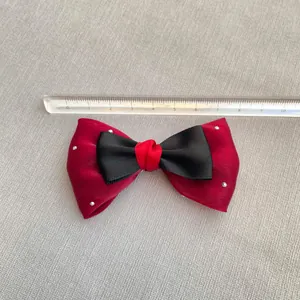 Close-up of a 10cm handmade red and black satin bowknot with silver polka dots