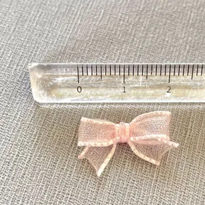 Close-up of pink mesh bow DIY accessory with scale ruler showing 2.5cm width