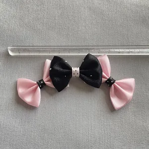 Pinza para pelo con lazo rosa y negro, lunares blancos y cristales sobre gris