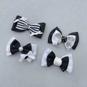 Detailed close-up of four black and white fabric bows with pearls and rhinestones