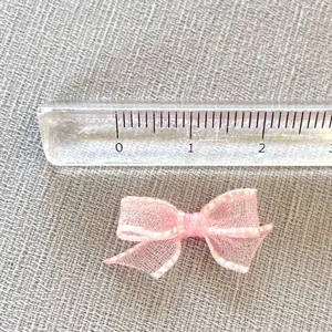 Detail shot of mini pink mesh bow accessory with measuring tape showing 2.5cm width