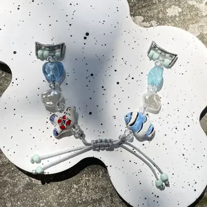 Handmade beaded blue heart watch strap with ceramic charms and adjustable woven cord