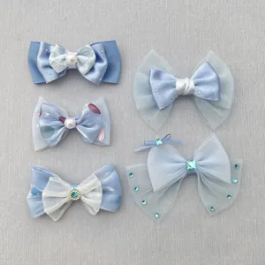 Detail van blauwe DIY handgemaakte haarstrikken met parels, strass en mesh-texturen