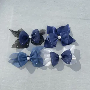 Detailed view of handmade bow accessories with satin ribbon, tulle, and pearl beads