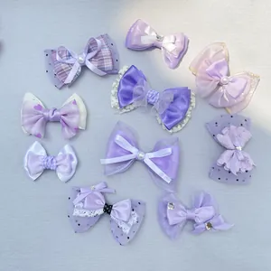 Detailed view of purple bow accessories featuring lace, satin, and checkered patterns