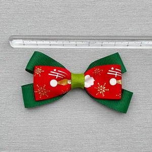 Green and red Christmas ribbon bow with gold snowflake patterns and size ruler