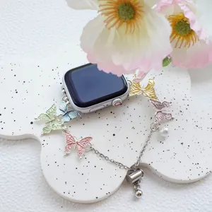Colorful butterfly Apple Watch bracelet with pearl pendant on a decorative tray