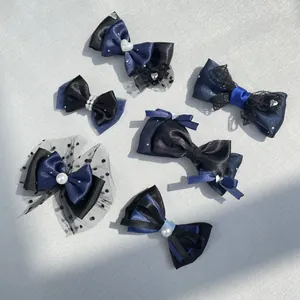 Dettaglio di fermagli per capelli a fiocco fatti a mano in blu navy e nero con perle e pizzo