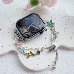 Detail of silver metal iWatch band with colorful enamel butterflies and rhinestones