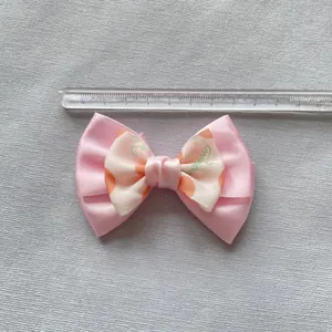 Detail view of 8cm dual-layer pink and white ribbon bow with ruler measurement
