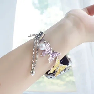 Detail of beaded butterfly charms and pearl pendant on a double-layer Apple Watch strap