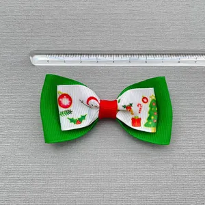 Christmas bow hair accessory with snowman pattern and ruler showing 8.5cm width