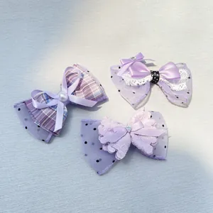 Detailed view of handmade purple bow hair clips with pearls, lace, and polka dot mesh