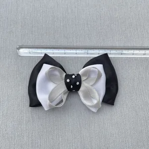 Close-up of handmade 8cm black and white cotton ribbon bow with measurement ruler