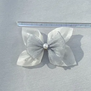 Close-up of double-layer mesh bow with rhinestones and pearl center showing 10cm size