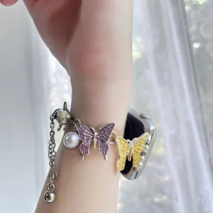 Close-up of butterfly link watch band with colorful enamel and white pearls details