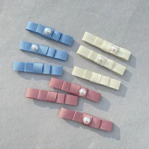 Detailed set of handmade satin bow hairclips with elegant white pearl accents in three colors