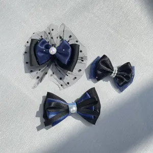 Dettaglio di fermagli per capelli fatti a mano blu scuro e nero con perle e rete