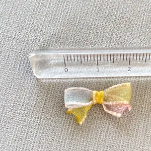 Detailed close-up of a 2cm mini mesh ribbon bow with multi-colored pastel tulle layers