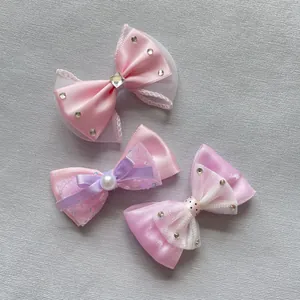 Detalle de lazos de malla rosa y morado con diamantes y perlas para accesorios de bricolaje