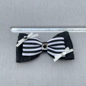Detail showing a 9cm black striped ribbon bow accessory with crystal rhinestones