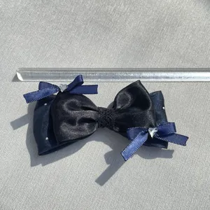 Dettaglio fiocco in raso blu navy con strass a cuore e decorazione in pizzo elegante