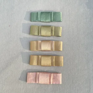 Close-up of five colorful satin bow accessories in green, orange and pink tones