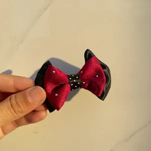 Close-up of handmade red and black satin bow with silver rhinestones for DIY hair accessories