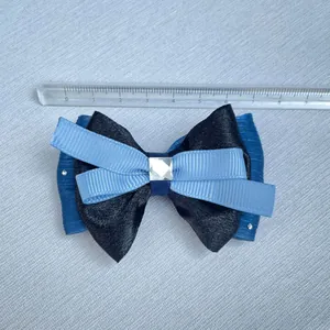 Detalle de un lazo azul de varias capas de 9 cm con un cristal brillante central