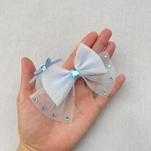 Detail van lichtblauwe gaasstrik met cyaan edelsteen en strassteentjes voor DIY-accessoires