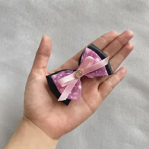 Primer plano de lazo para el pelo hecho a mano negro y rosa con malla de copos y cristal