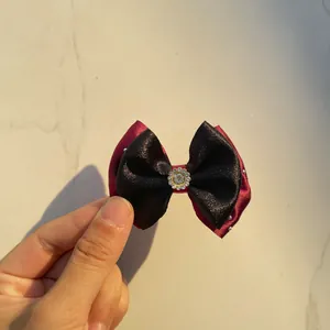 Close-up of handmade double-layered black and red satin bow with sparkling rhinestone center