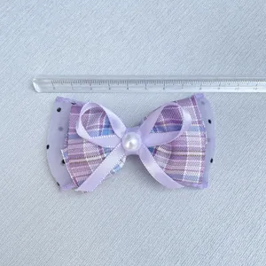 Purple bow accessory with polka dot tulle, plaid fabric, and pearl for DIY crafts