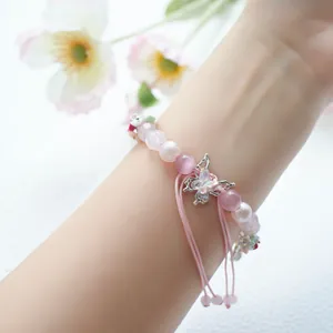 Detail of pink crystal beaded iWatch strap with silver butterfly and flower charms