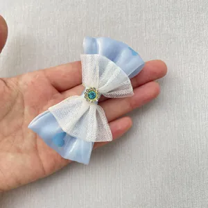 Detail van een handgemaakte blauwe strik met zonnebloemjuweel in de hand voor schaal