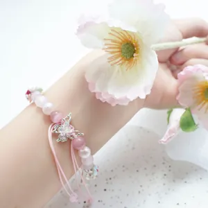 Detail of pink cat-eye beads and silver butterfly charm on adjustable iWatch strap