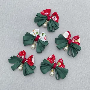 Detailed macro view of festive Christmas bow hair accessories with pearls and elk patterns