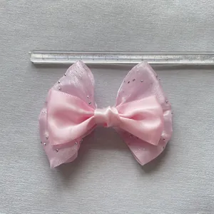 Detalle de un lazo de malla rosa de doble capa con diamantes de imitación para manualidades