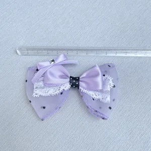 Macro detail of purple layered mesh bow with white lace and center rhinestone decoration