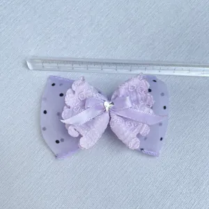Detail view showing a 11cm purple layered ribbon bow with lace and a heart rhinestone