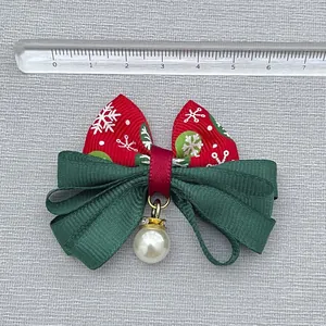 Christmas bow hair accessory with red snowflake print and pearl detail on gray background