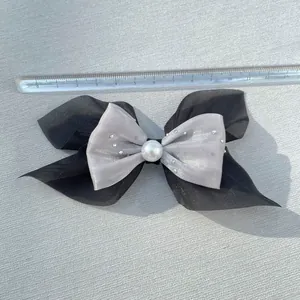 Close-up of a 13cm black chiffon and silver silk ribbon bow hairclip with pearl and rhinestones