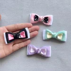 Detailed view of four handmade polka dot satin bows with heart charms and white ribbon base